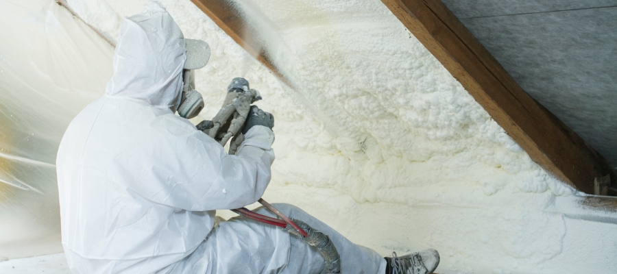 Man sprays insulation in attic